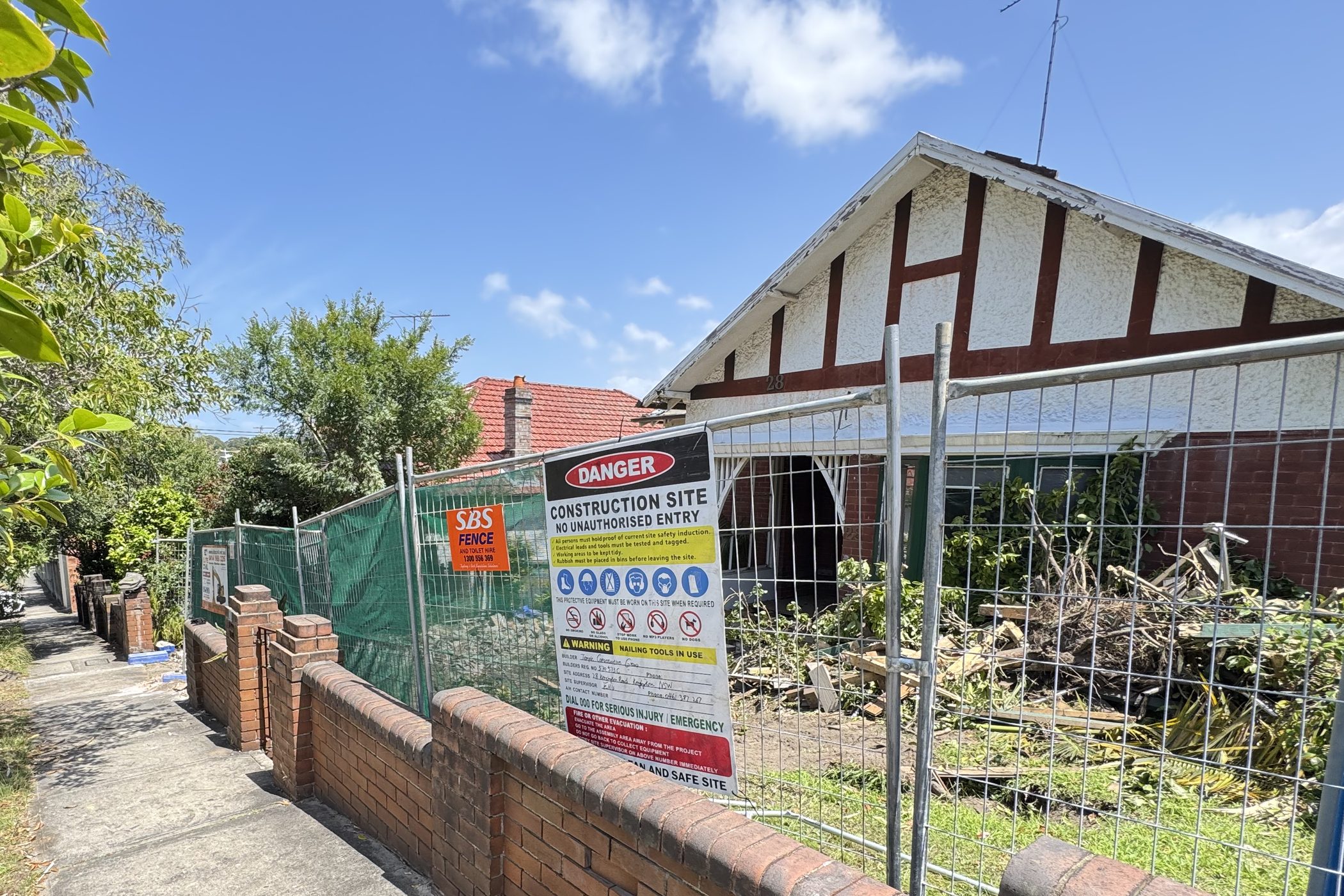 The original cottage on the block, fenced as a site, before demolition.