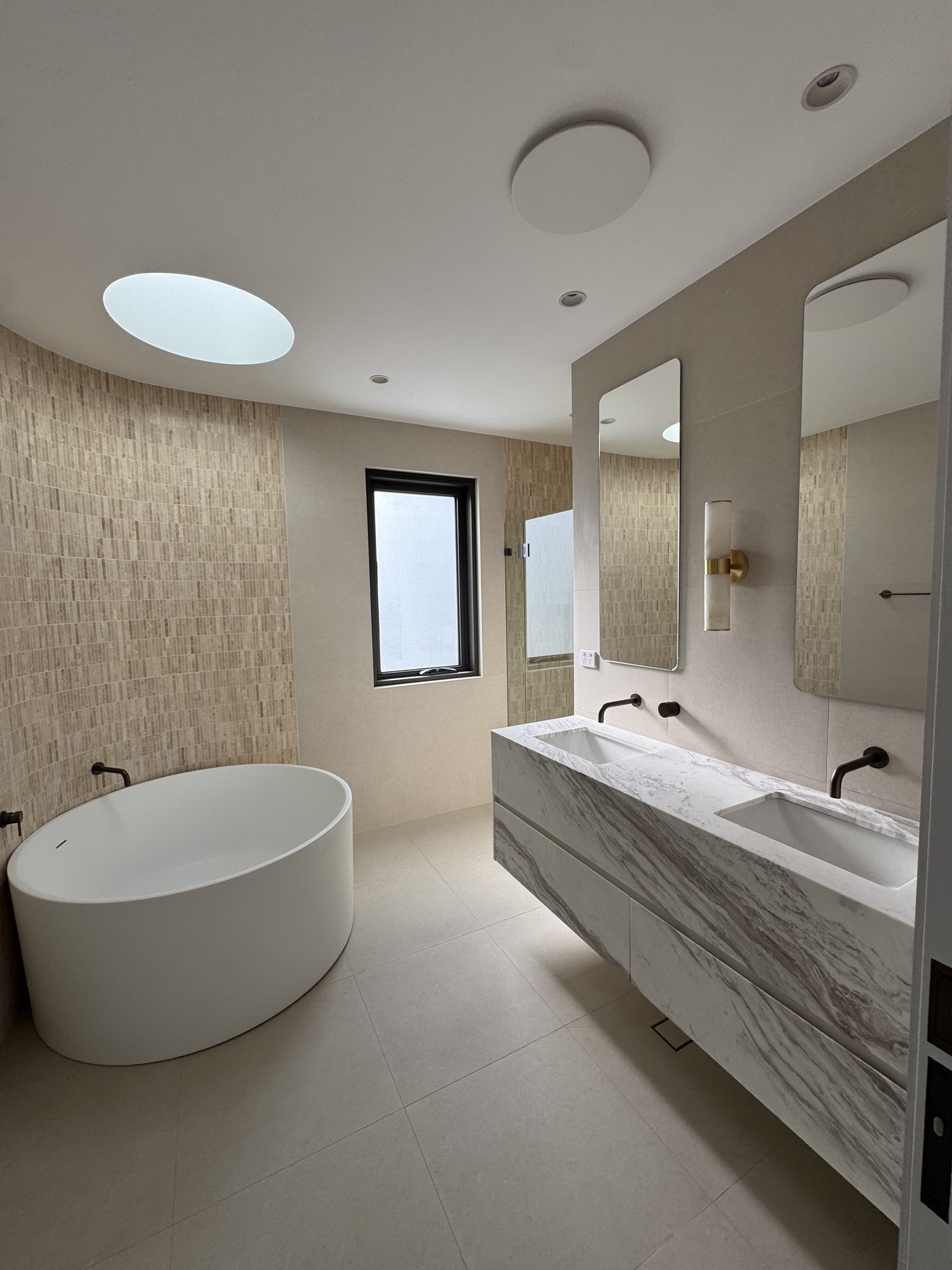 Main ensuite with a freestanding bath and a stone double vanity
