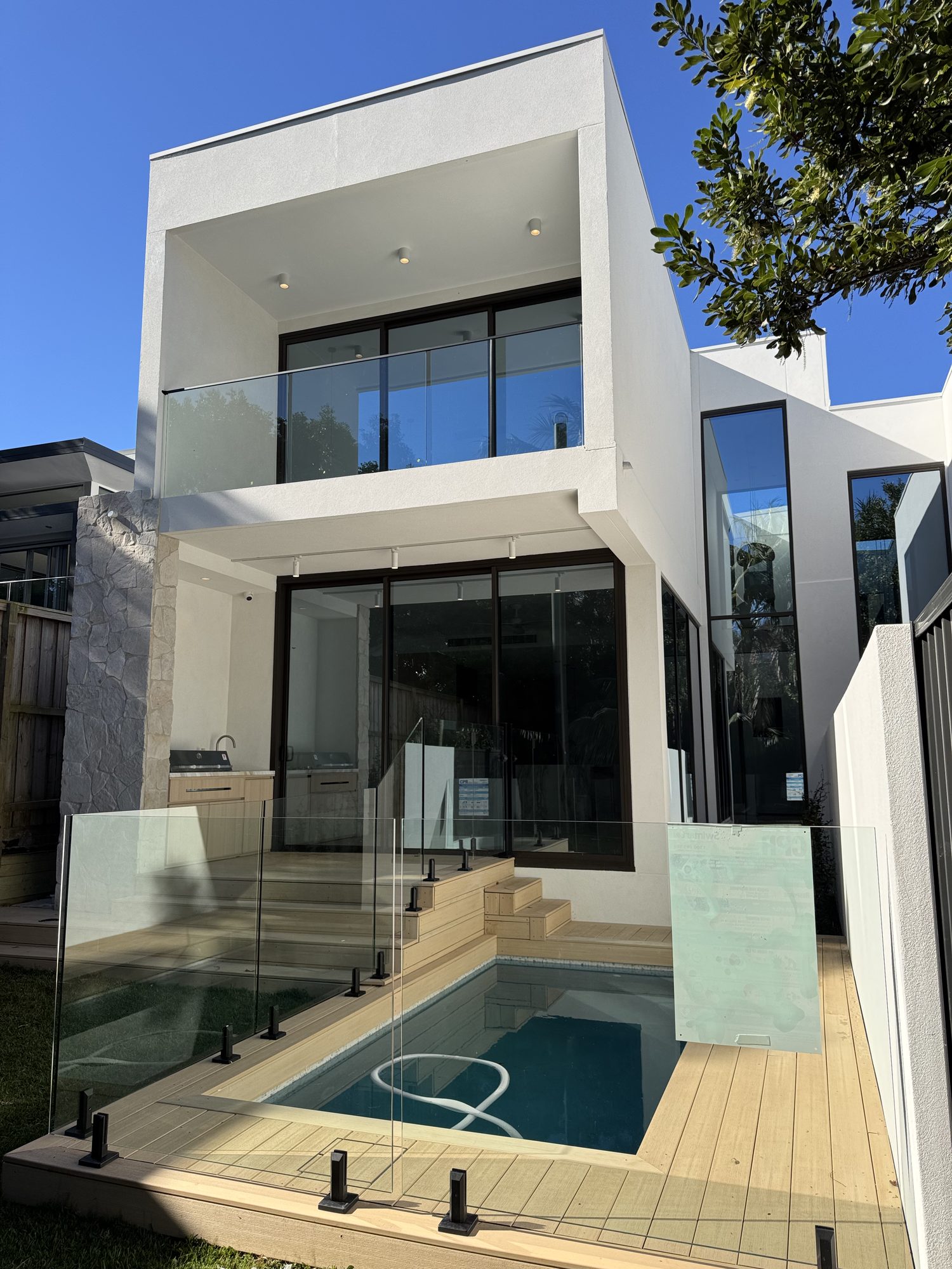 The completed home: two storeys, glazed to the rear, with a pool and deck